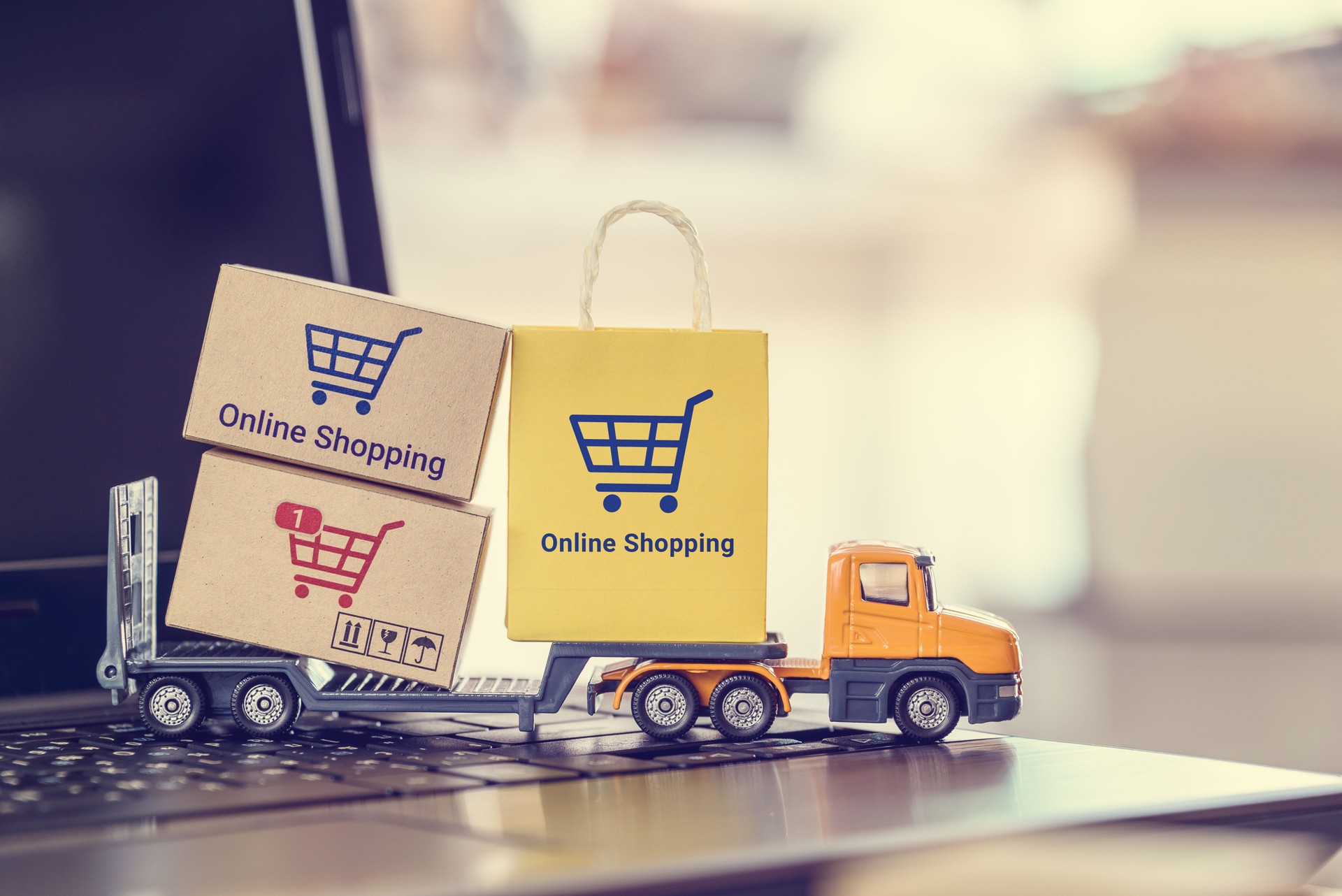 Online shopping, e-commerce industry, delivery services, and the convenience of purchasing goods via digital platforms : The miniature trailer truck carrying boxes and a bag labeled "online shopping".